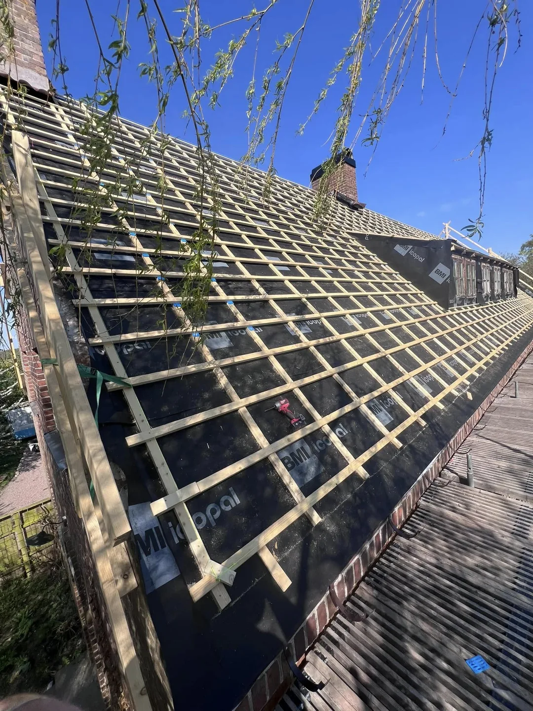 Pågående takarbete med ny läkt och underlagstäckning.